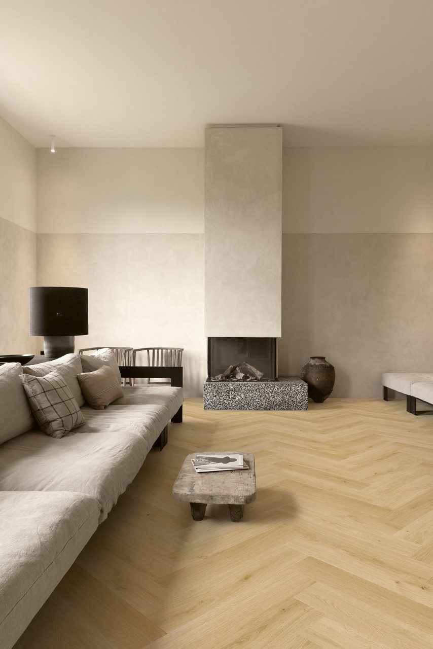 Fischgrät Laminatboden Quick Step Impressive Design Gardamom Oak, verlegt im Wohnzimmerboden, Sofa, Tisch und Kamin