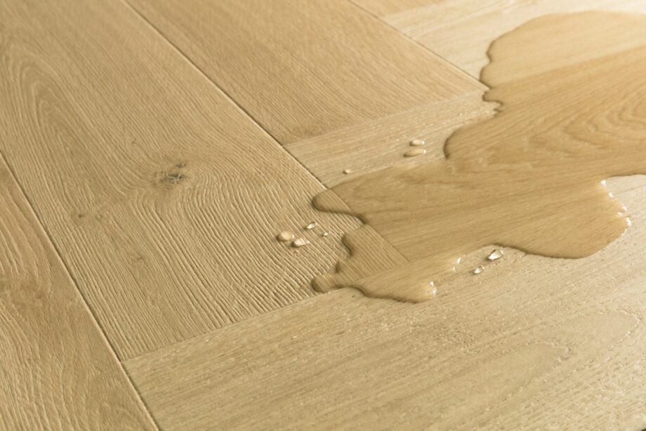 kalanruotolaminaatti-quick-step-pergo-impressive-design-gardamom-oak Kalanruotolaminaatti Quick Step Pergo Impressive Design Gardamom Oak, vaaleanruskea tammen sävy ja tasainen lajitelma, vesilätäkkö osoittamassa vedenkestävyyttä