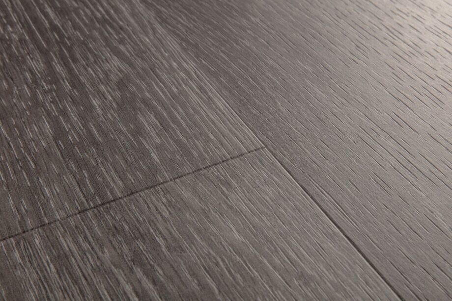 Vinyylilankku Quick Step Blos Silk tammi Dark Grey asennettu lattialle harmaan tumma tammikuosi luonnollinen puunsyy ja hillitty sävyvaihtelu moderni vinyylilattia sisustuksessa