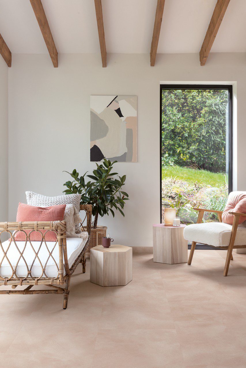 LVT põrandakate Quick-Step Illume Soft blush paigaldatud elutoa põrandale. Lamamistool, tugitool roheline taim ja teelauad toolide kõrval.