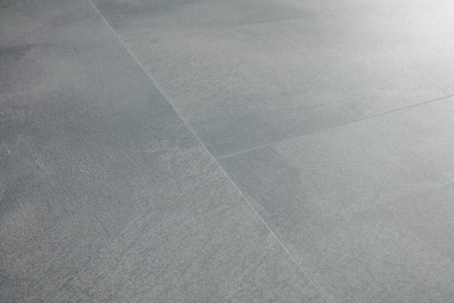 Vinyylilattia Quick-Step Illume Soft Sky asennettuna kodin lattialle – vaalea, raikas harmaansininen sävy ja hillitty kivimäinen/betonimainen design hienovaraisella tekstuurilla.