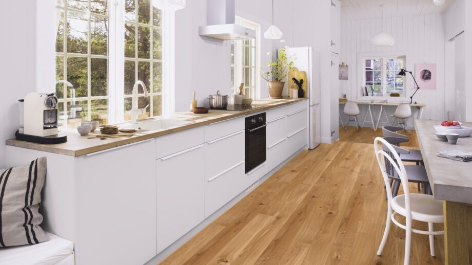 Wooden floor Bauwerk Casapark Oak 46 bavelled, brushed and matt lacquered installed on kitchen floor. Kitchen furniture, dining table.