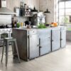 LVT parkett Quick-Step Blos Cayon tamm grey saw cuts paigaldatud köögi põrandale. Metallist köögimööbel ja köögisaar.