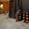 Vinyl floor tiles Quick-Step Oro Concrete rock installed on a home Jim floor. Ladder on wall, yoga mat.