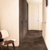 vinyl-flooring-tiles-quick-step-oro-cinnamon-rock Vinyl flooring tiles Quick-Step Oro Cinnamon rock with dark brown bevelled natural stone flooring design. Installed on a hallway floor. Cow leather stool, integrated hallway closet.