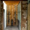 Vinyl flooring tiles Quick-Step Oro Concrete rock installed to a rustic style hallway floor.